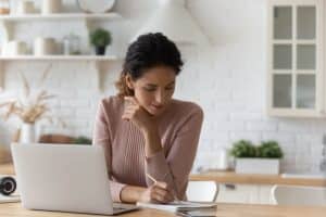 woman in front of laptop taking notes event planning mistakes