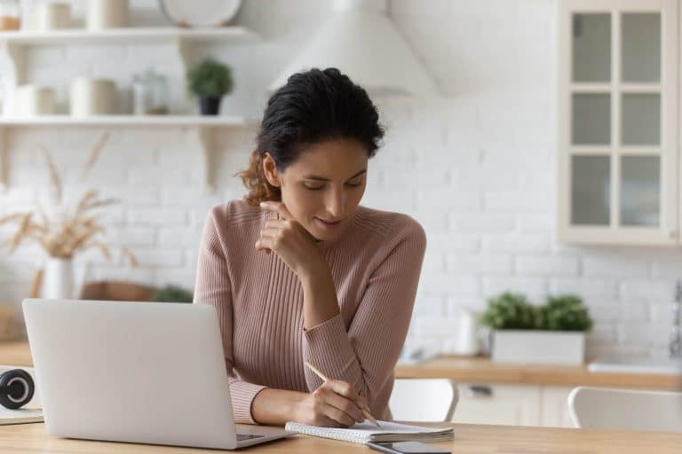 woman in front of laptop taking notes event planning mistakes